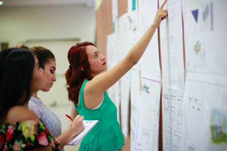 une fille qui pointe le doit sur le tableau